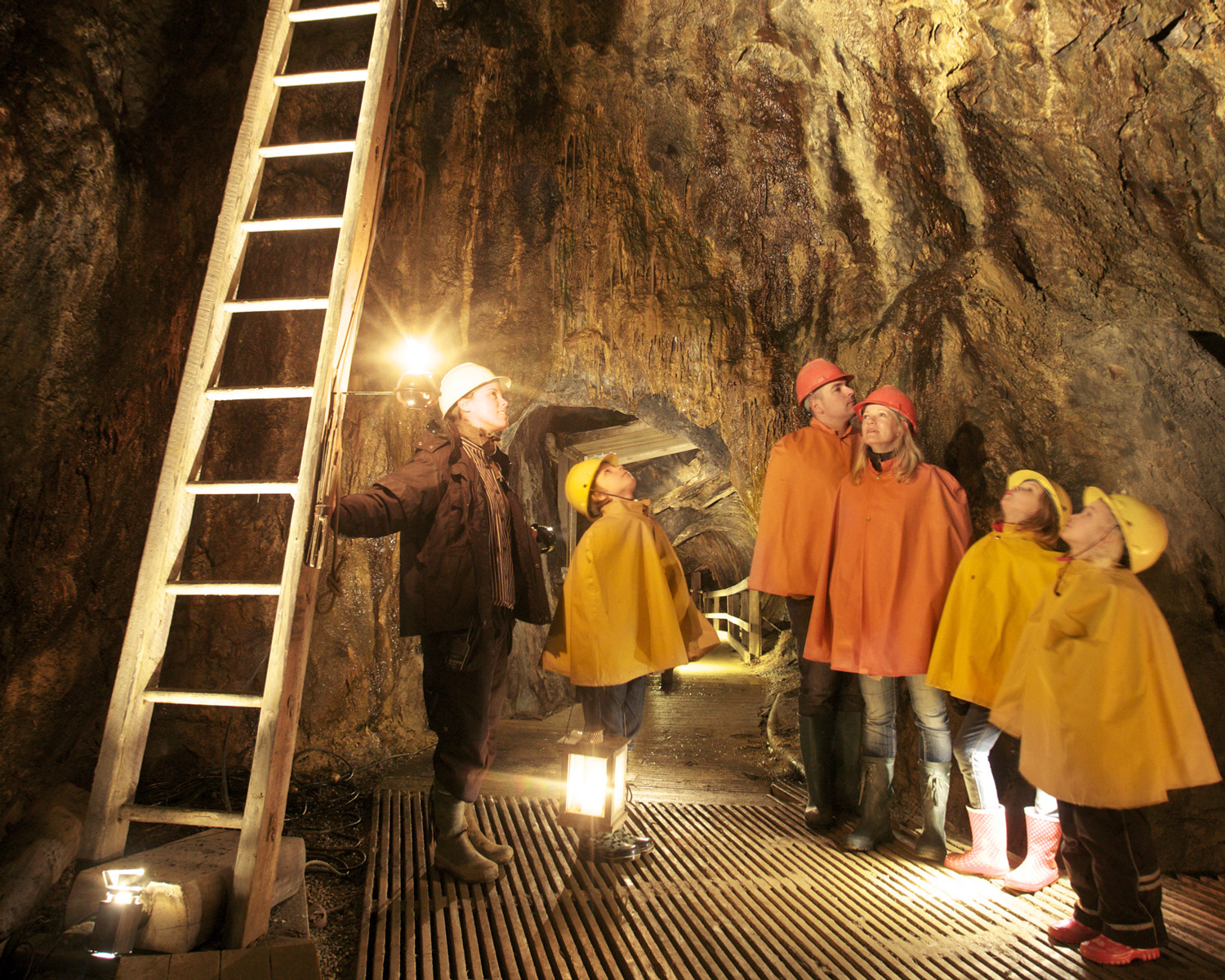 En guidad grupp står i ett bergrum nere i en gruva.