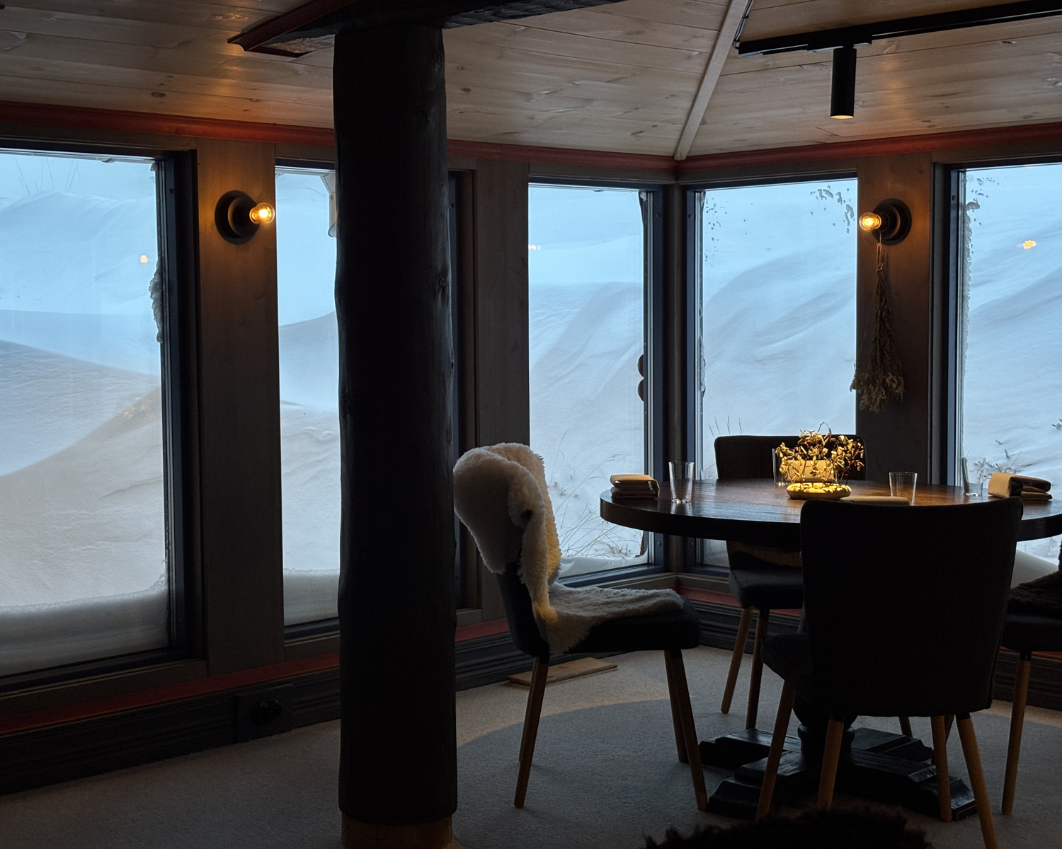 Ett bord intill fönster med vidunderlig utsikt över fjällandskap.