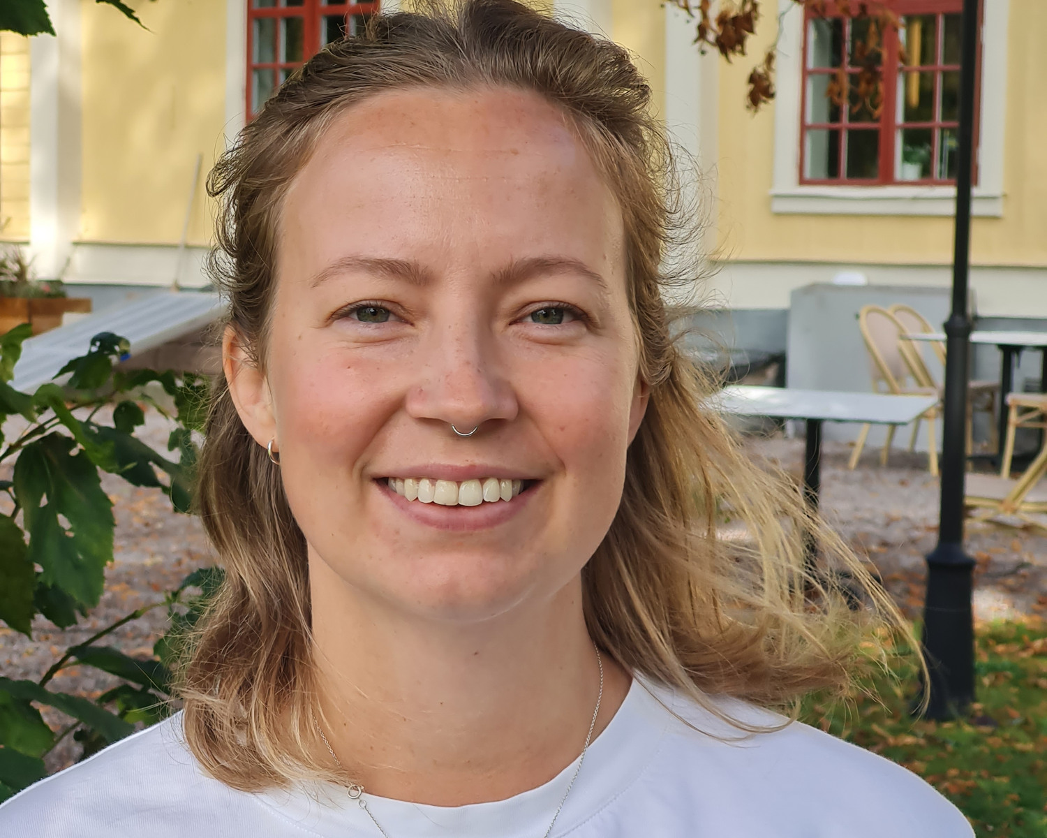 Porträtt på kvinna i vit t-shirt utomhus