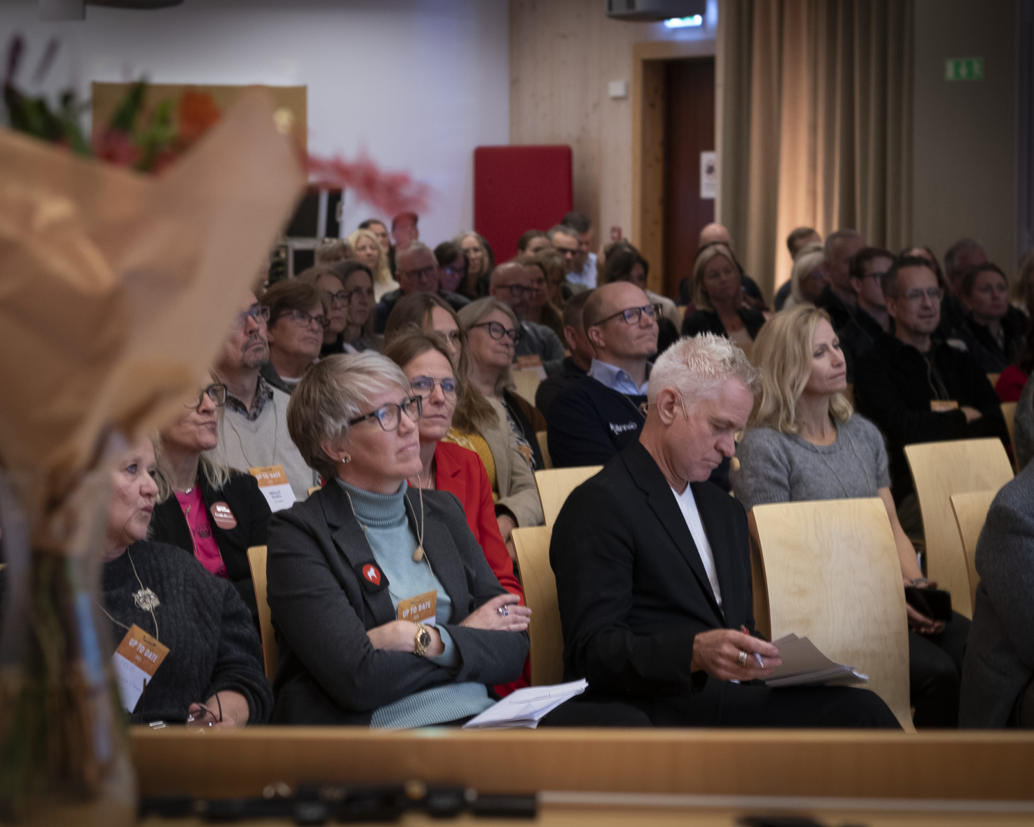 En publik sitter på stolar och tittar upp mot en scen.