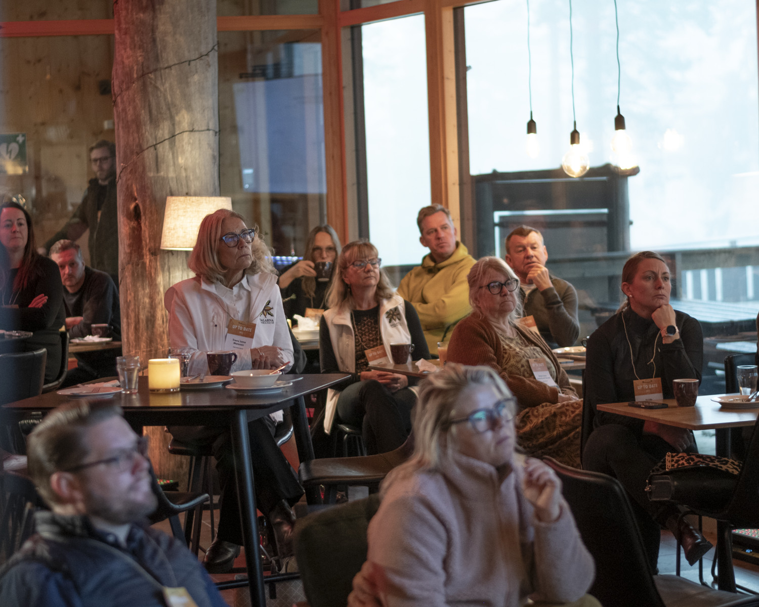 En grupp människor sitter och lyssnar uppmärksamt.