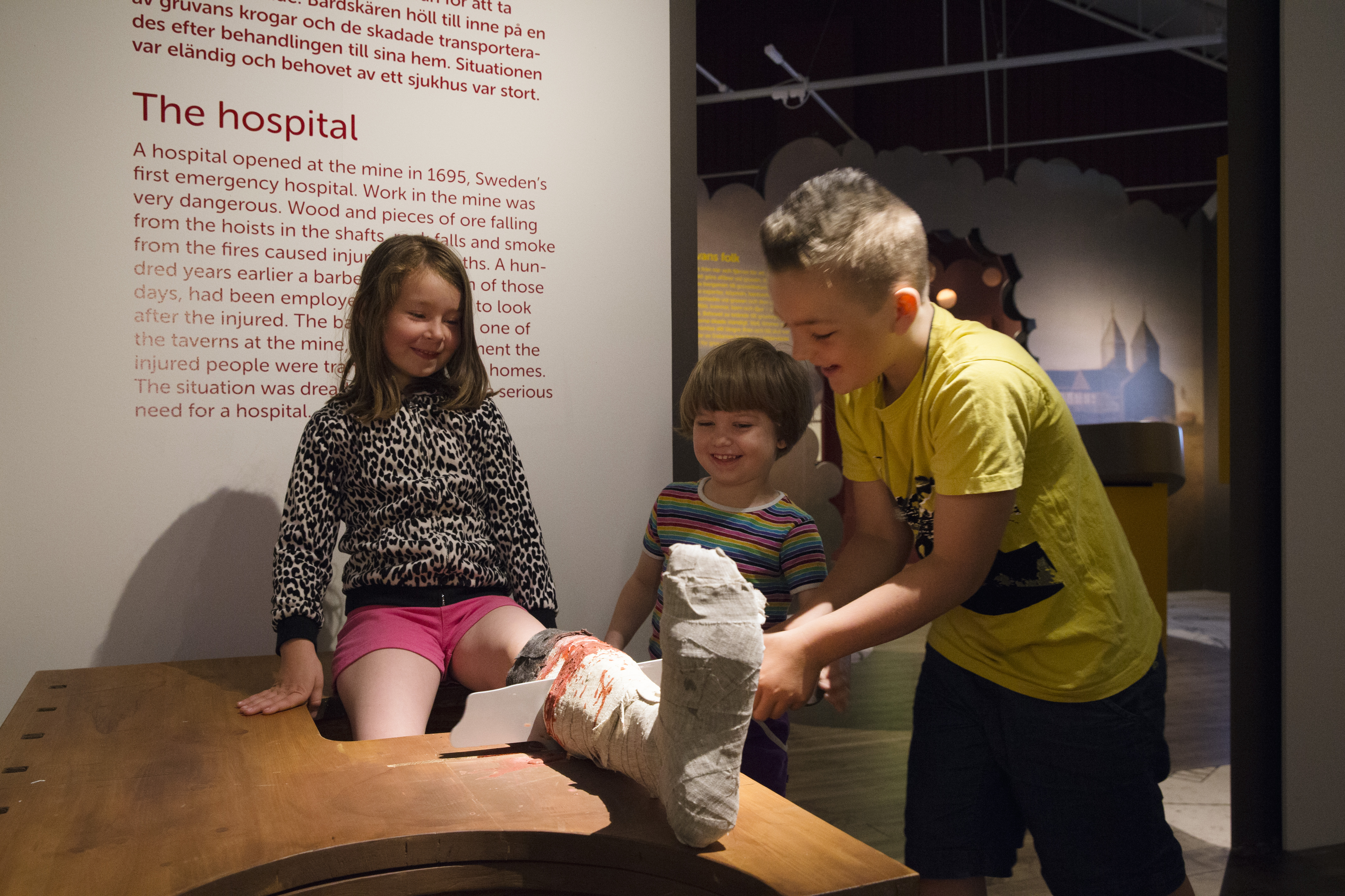 Två barn och en vuxen utforskar Falu Gruvas gruvmuseum.