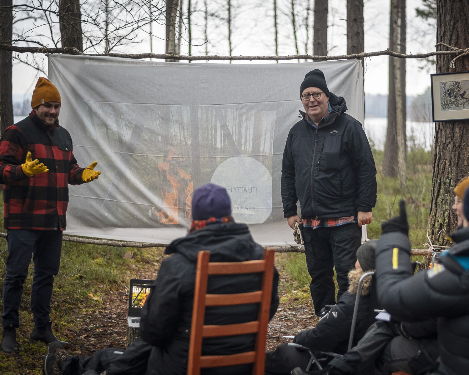 Två personer håller i ett möte utomhus i skogen.