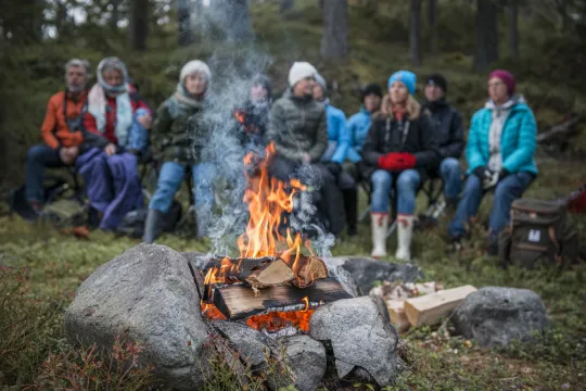 En grupp människor sitter runt en eld.
