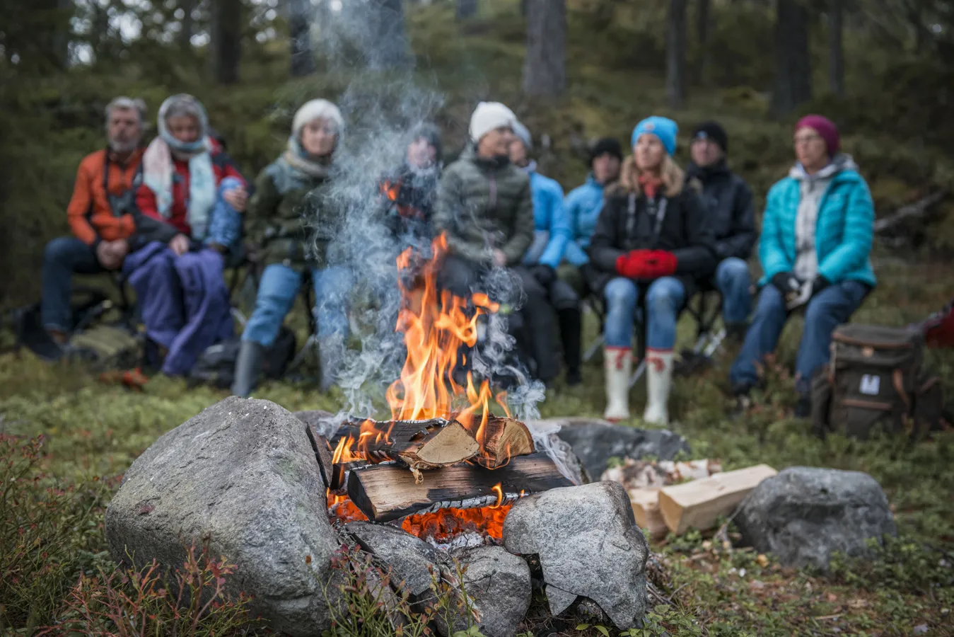 En grupp människor sitter runt en eld.