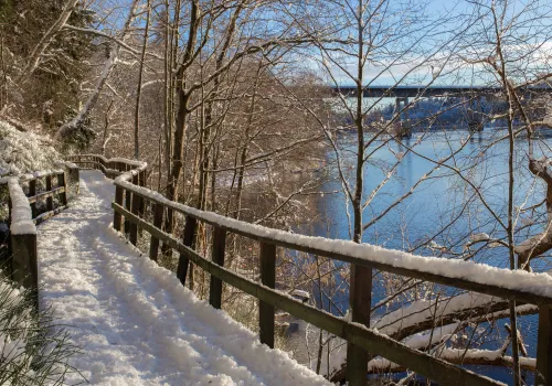 En gångbro intill älv vintertid.