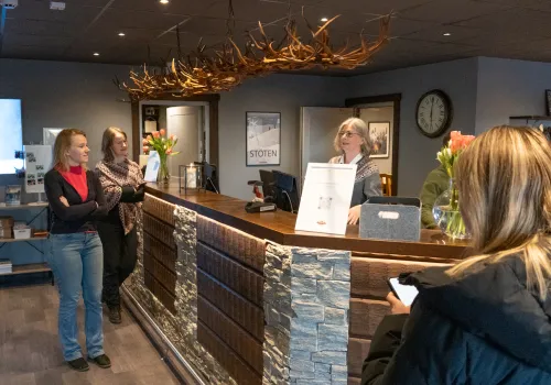 Gäster står vid en receptionsdisk på ett hotell.