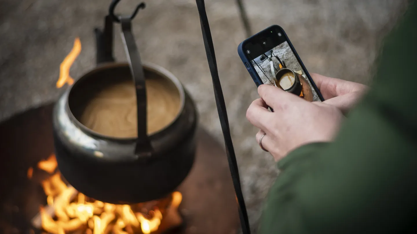 Människa som fotograferar en kaffepanna med mobilen