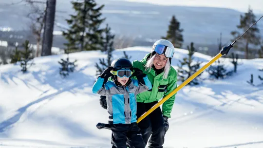 Vuxen och barn på väg upp i liften på Idre Himmelfjäll.