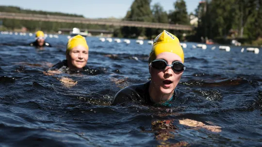 Simmare i gula badmössor under Vansbrosimningen