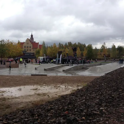 Slagghögar längst fram i bildkant, skatepark en höstdag en gul byggnad och ett kyrktorn i bakgrunden.