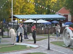Personer som spelar bangolf, servering i bakgrunden.