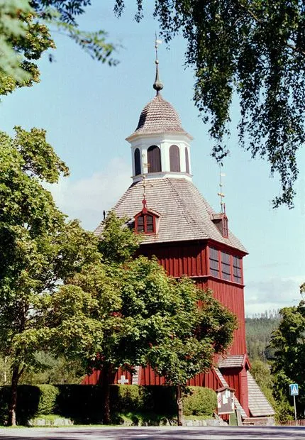 En röd träkyrka med ett vitt torn.