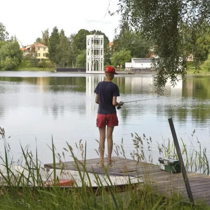 Pojke metar från en brygga med en båt förankrad bredvid.