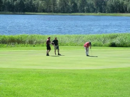 Tre personer på golfbana.