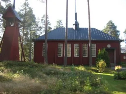 Rött trähus med höga fönster.