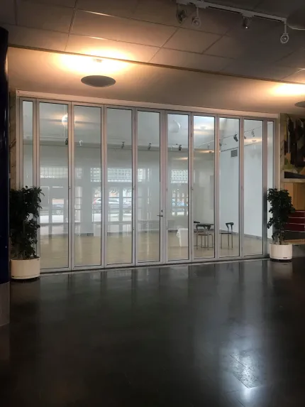 Ett rum med glasad vägg och med två växter ståendes på varsin sida av glasväggen.
