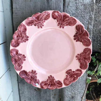 Rund rosa tallrik med blommönster.