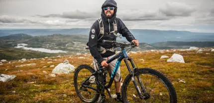 A man with his bike on the mountain. 