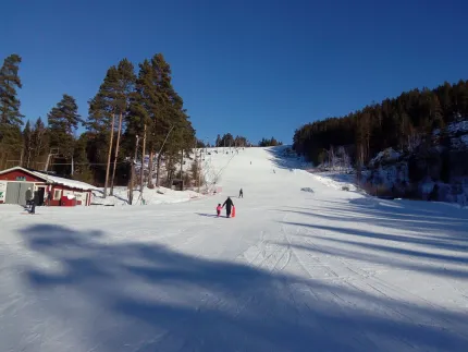 One of the skislopes with some people are skiing.