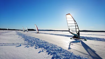 Flera isjakter på rad på plogad isbana på sjö.