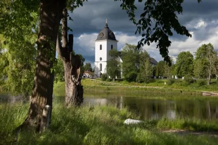 Church next to lake with trees.