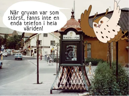 En äldre telefonkiosk vid en gata.