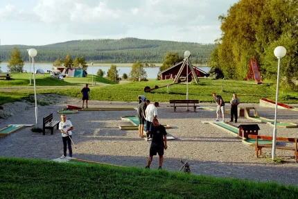 Bangolfbana på Särna Camping med sjö i bakgrunden och folk som spelar. 